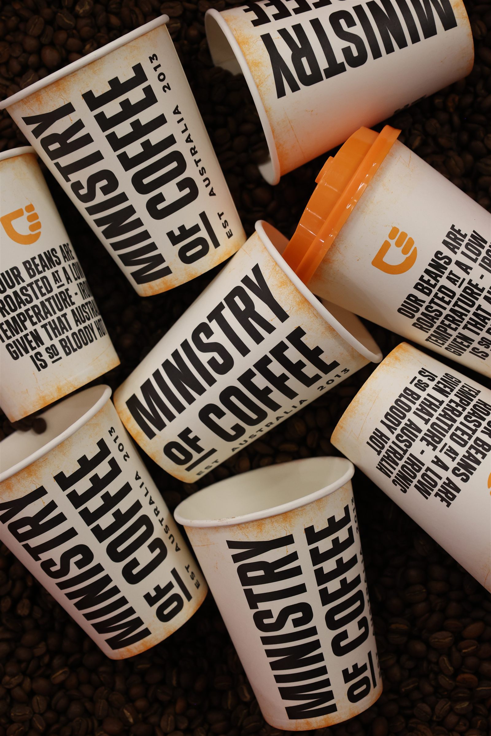 Ministry of Coffee cups arranged on roasted coffee beans