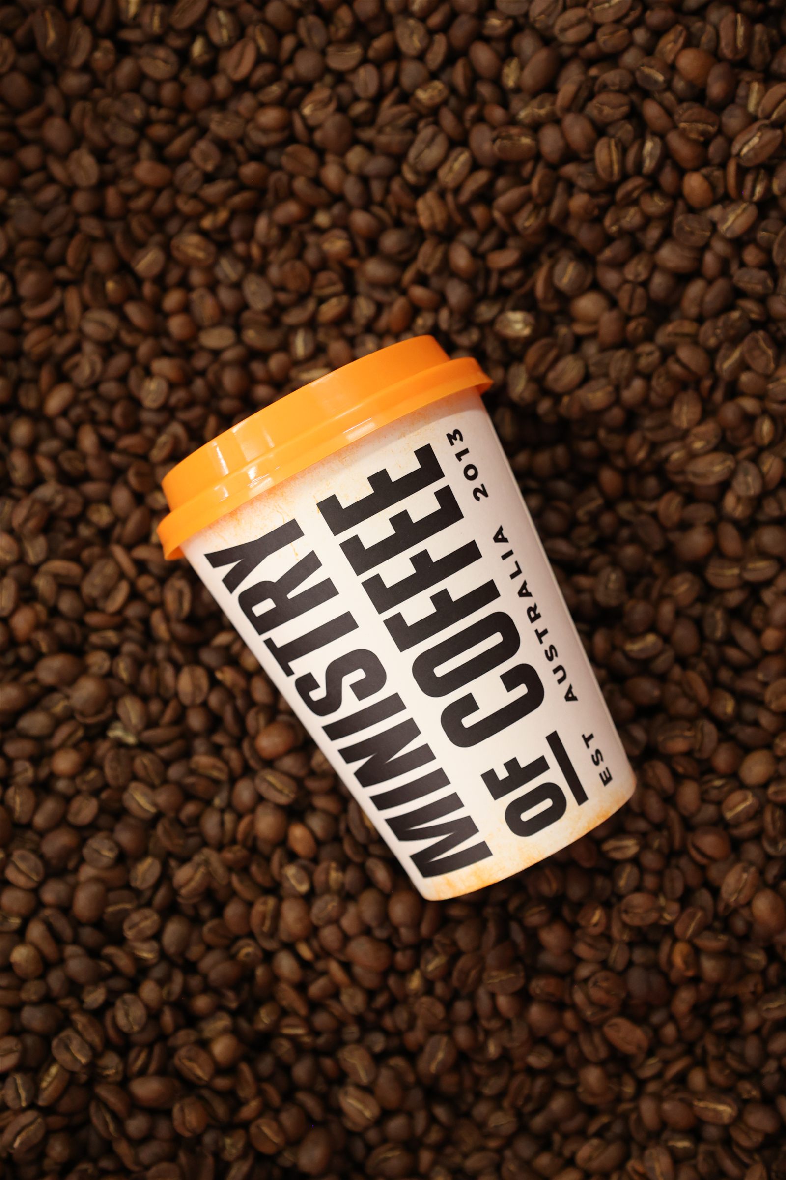 Ministry of Coffee cup on roasted coffee beans